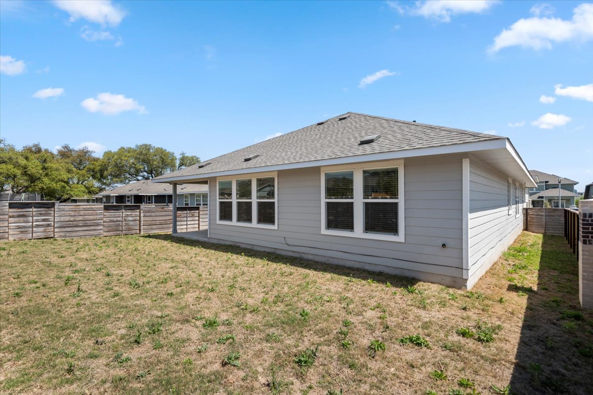 167 Jeffers Kyle, TX 78640 - Photo 37 of 40 Rear view of house with a fenced backyard and roof with shingles
