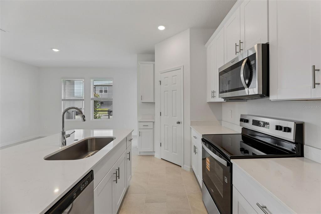 4574 Homestead Trail St. Cloud, FL 34772 - Photo 13 of 31 a kitchen with stainless steel appliances granite countertop a sink stove and refrigerator