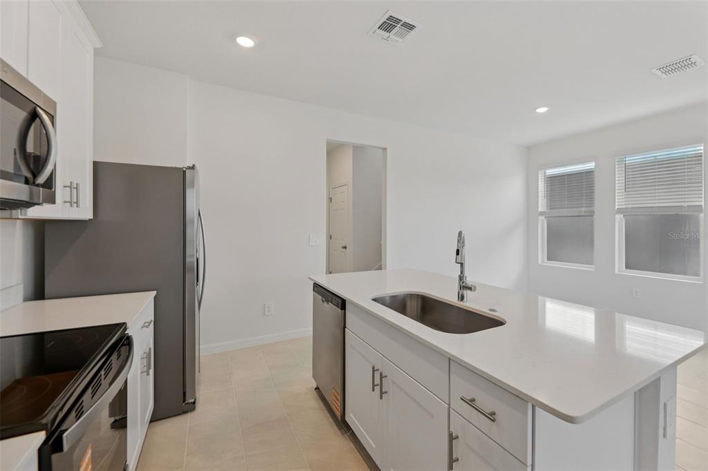 4574 Homestead Trail St. Cloud, FL 34772 - Photo 14 of 31 a kitchen with stainless steel appliances granite countertop a sink and a stove