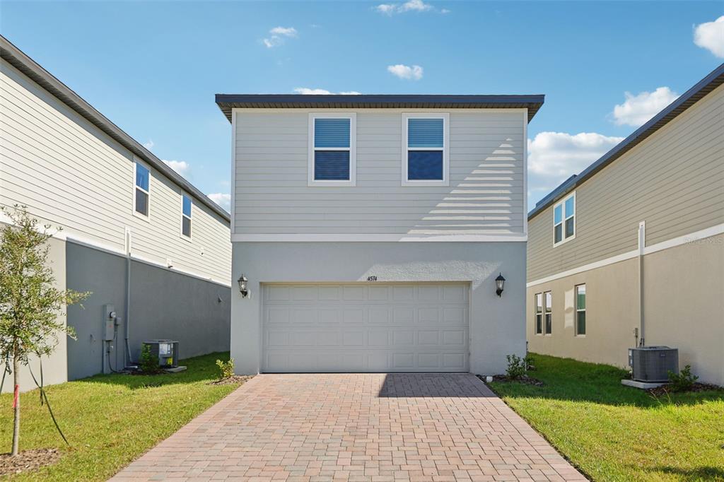 4574 Homestead Trail St. Cloud, FL 34772 - Photo 29 of 31 a front view of a house with a yard and garage