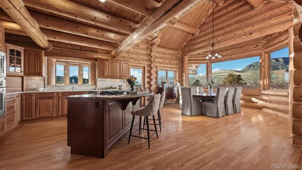 a dining hall with stainless steel appliances granite countertop a stove and wooden cabinets