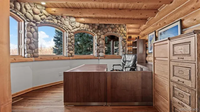 a view of a hallway with wooden floor and a large window