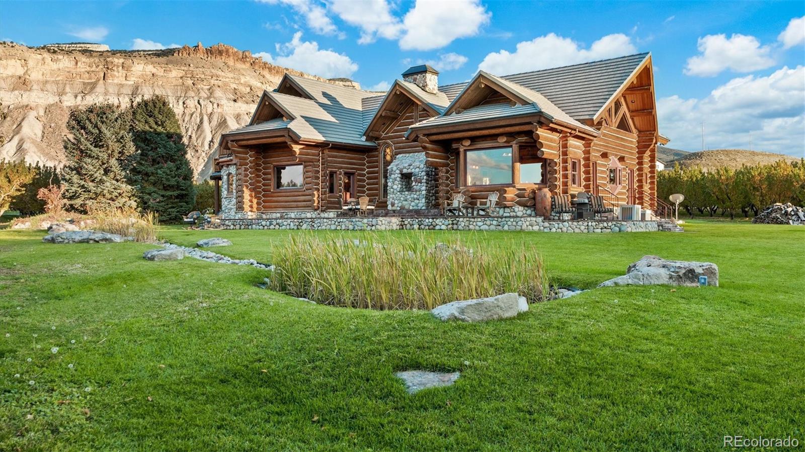 3875 F F 3/4 Road Palisade, CO 81526 - Photo 9 of 45 a front view of a house with a yard table and chairs