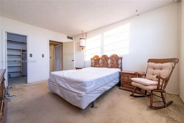 a spacious bedroom with a bed and a cabinets