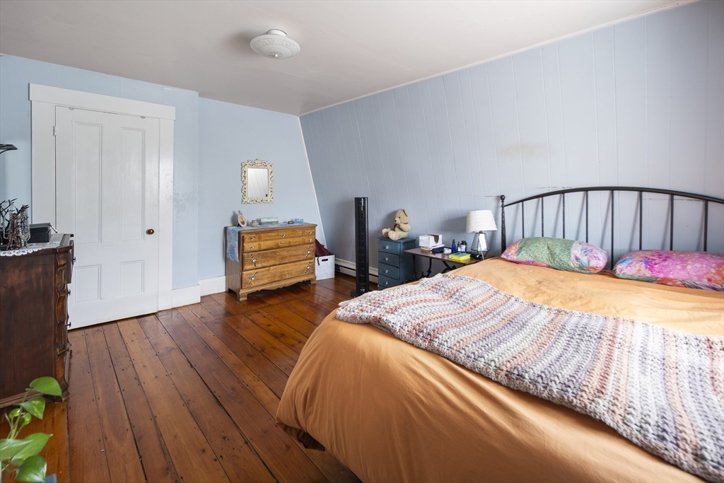 38 Spring Street Somerville, MA 02143 - Photo 27 of 37 a bed sitting in a bedroom and dresser with wooden floor