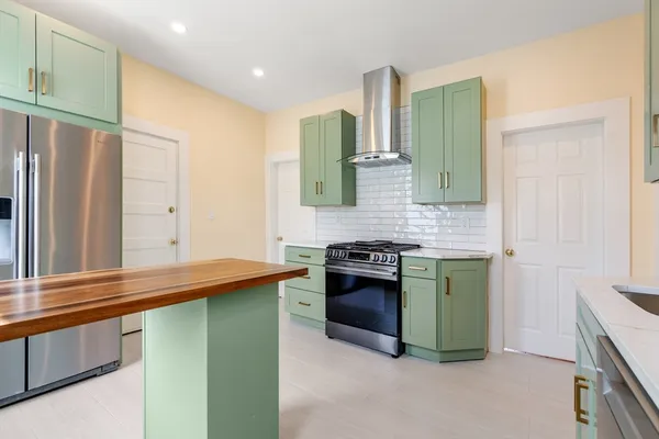a kitchen with stainless steel appliances granite countertop a refrigerator and a sink