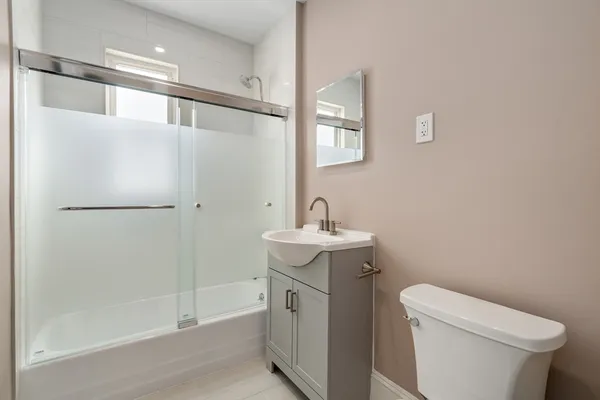 a bathroom with a sink a toilet and shower