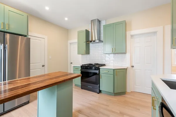 a kitchen with stainless steel appliances granite countertop a refrigerator and a stove