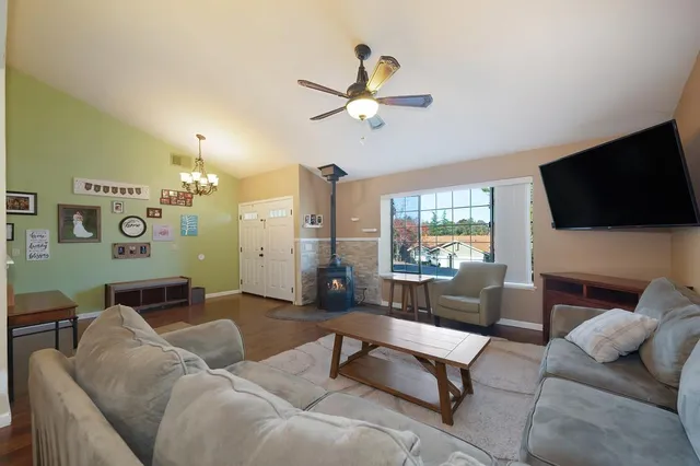 a kitchen with stainless steel appliances granite countertop a refrigerator a sink dishwasher a stove and white countertops with wooden floor