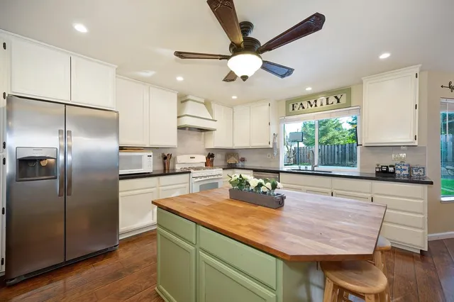 a kitchen with stainless steel appliances granite countertop a stove refrigerator sink and cabinets