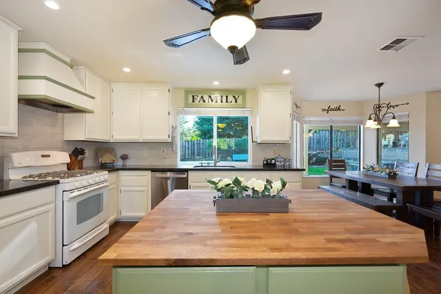 a view of a dining room and livingroom with furniture wooden floor a chandelier
