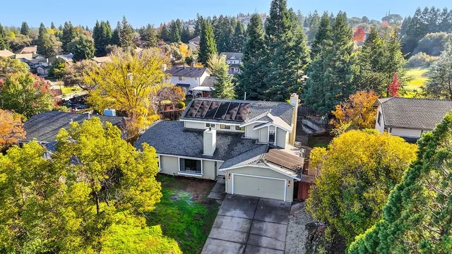 a view of a house with a yard and trees