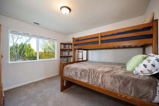 a bedroom with a bed a couch and a flat screen tv