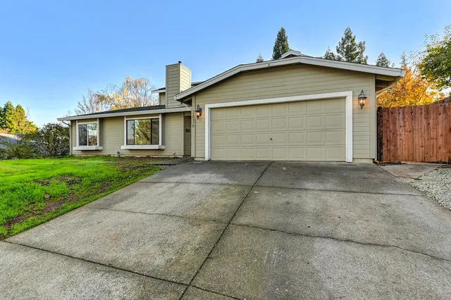a view of house with a yard and potted plants