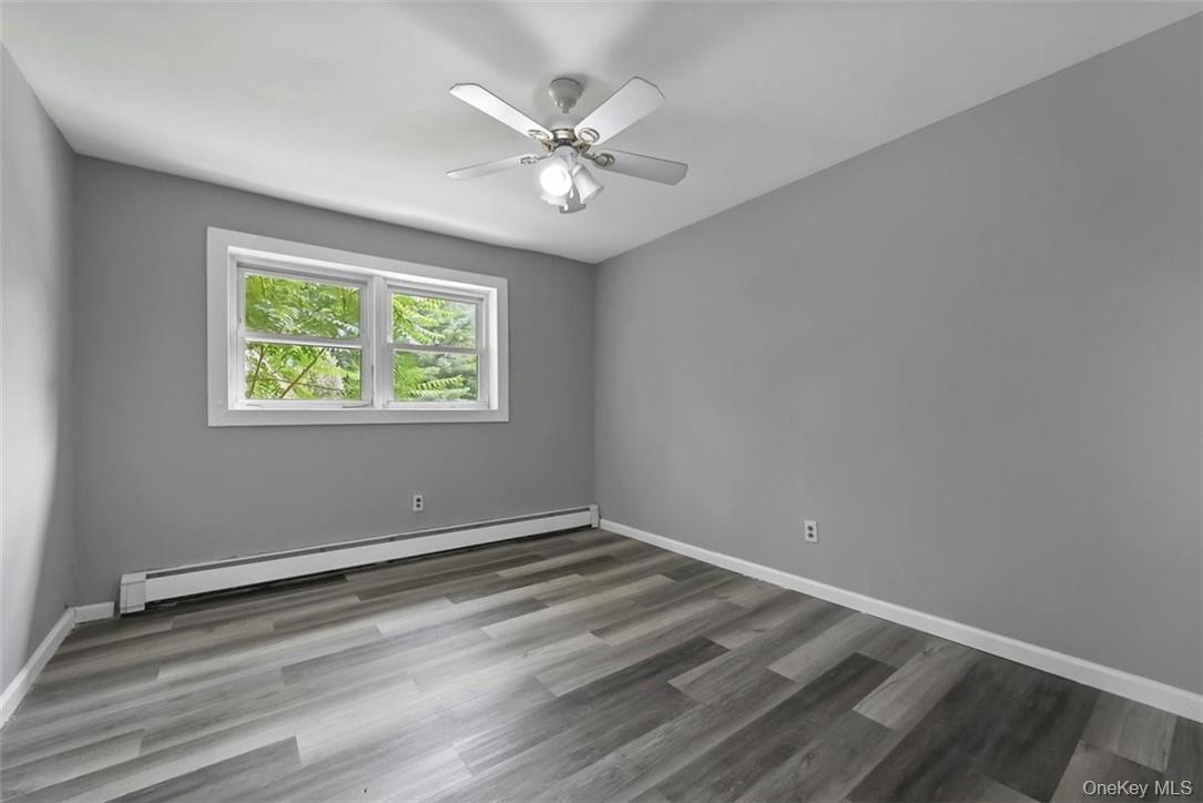 35 Peddler Hill Road Monroe, NY 10950 - Photo 13 of 23 Empty room with a baseboard heating unit, hardwood / wood-style floors, and ceiling fan