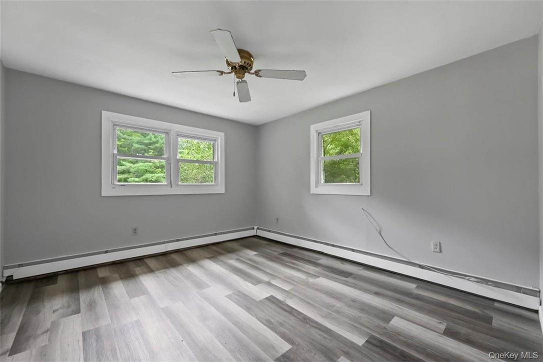 35 Peddler Hill Road Monroe, NY 10950 - Photo 15 of 23 Unfurnished room with light wood-type flooring, ceiling fan, a wealth of natural light, and a baseboard heating unit