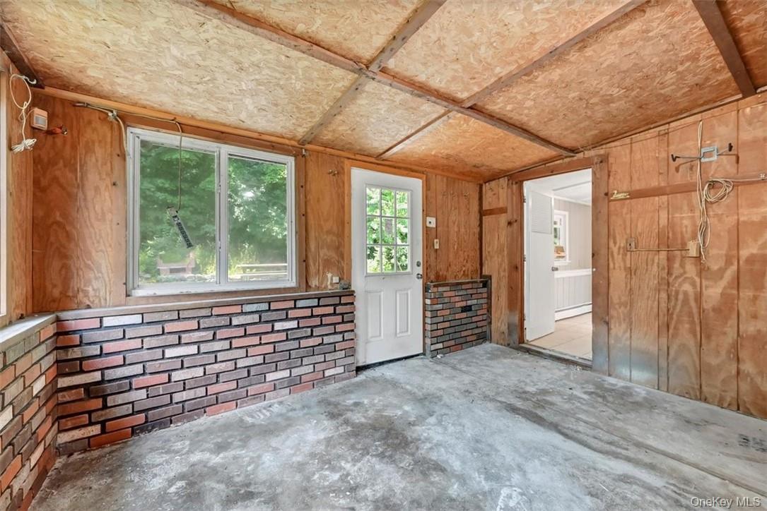 35 Peddler Hill Road Monroe, NY 10950 - Photo 19 of 23 Spare room featuring concrete floors, lofted ceiling, wooden walls, and a baseboard radiator