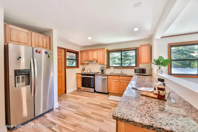 a kitchen with stainless steel appliances granite countertop a refrigerator stove and sink