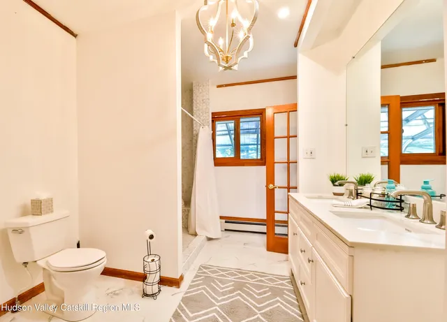 a spacious bathroom with a double vanity sink toilet and a tub