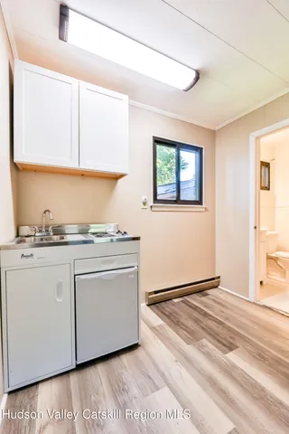 a view of kitchen with granite countertop cabinets appliances and a window