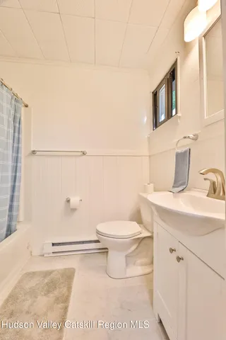 a bathroom with a sink a toilet and mirror