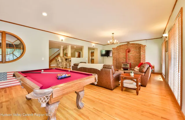 a living room with furniture a rug and a pool table