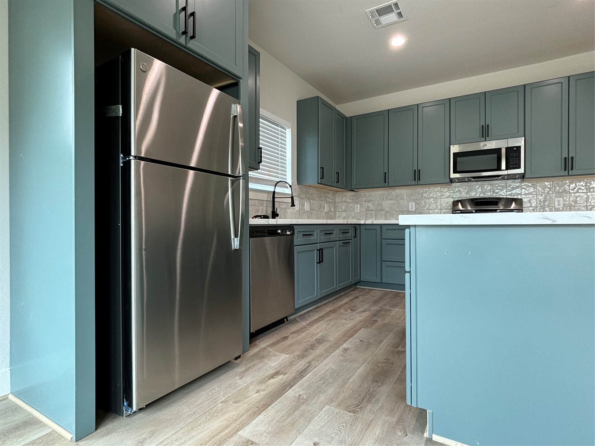 3604 Dennis Street Houston, TX 77004 - Photo 3 of 20 a kitchen with stainless steel appliances granite countertop a refrigerator a stove a sink and a microwave