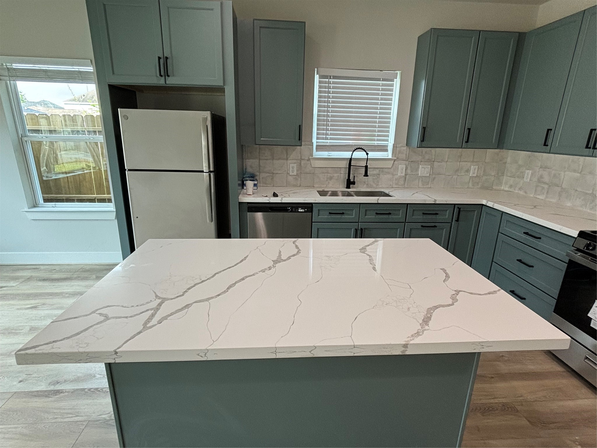 3604 Dennis Street Houston, TX 77004 - Photo 4 of 20 a white kitchen with a sink and wooden cabinets