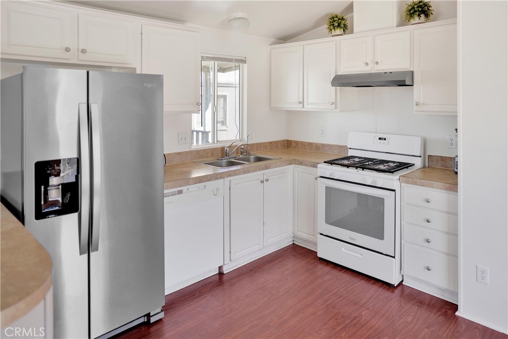 22601 Bear Valley Road, Unit 17 Apple Valley, CA 92308 - Photo 20 of 36 a kitchen with stainless steel appliances white cabinets and a refrigerator