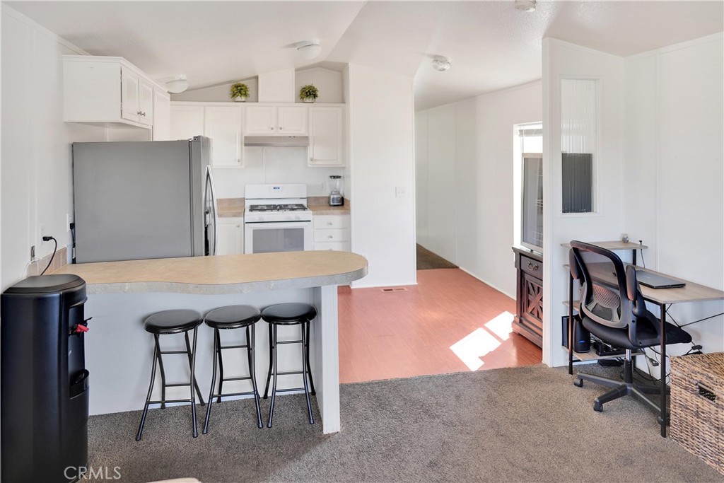 22601 Bear Valley Road, Unit 17 Apple Valley, CA 92308 - Photo 21 of 36 a kitchen with kitchen island a stove a table and chairs in it