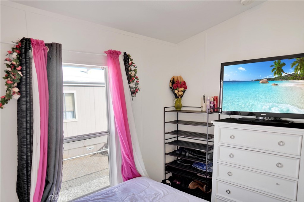22601 Bear Valley Road, Unit 17 Apple Valley, CA 92308 - Photo 9 of 36 a view of a living room with closet and a flat screen tv