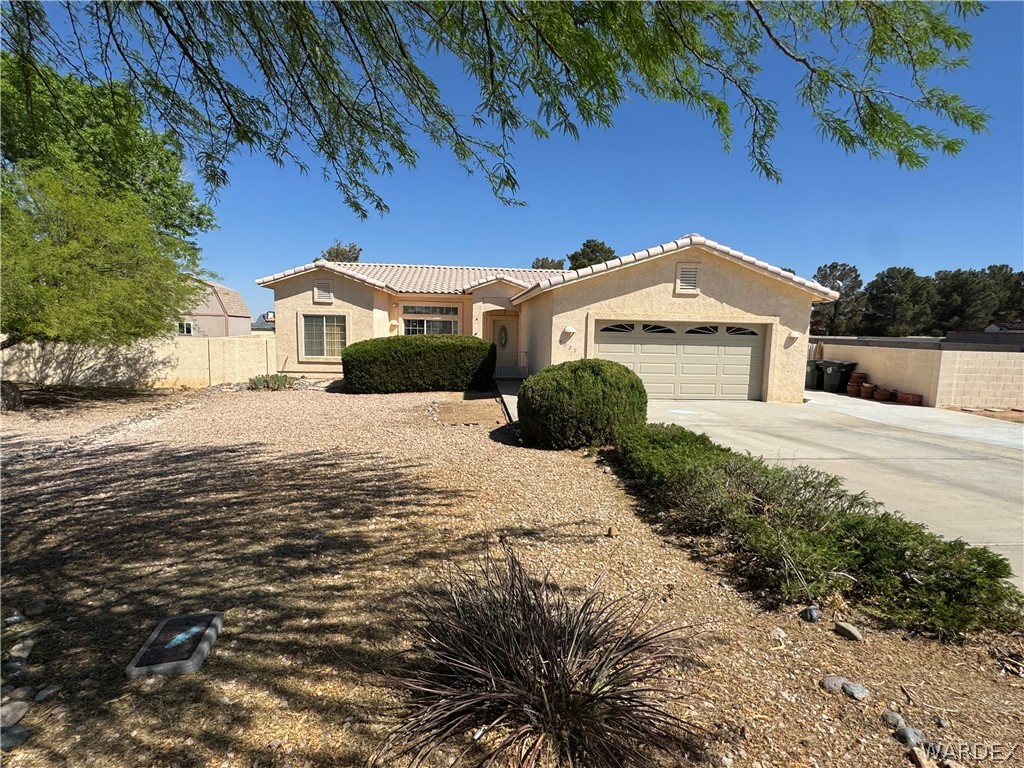 4029 Roma Road Kingman, AZ 86401 - Photo 1 of 90 The property features a single-story stucco exterior with a tiled roof, an integrated garage, and a concrete driveway