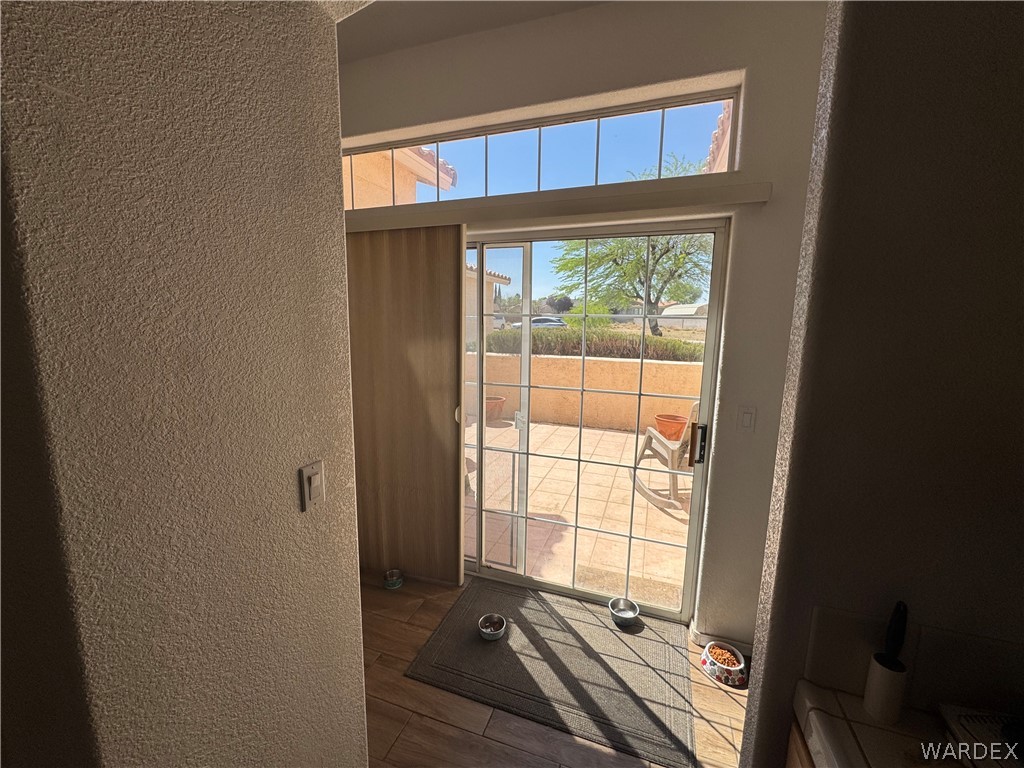 4029 Roma Road Kingman, AZ 86401 - Photo 26 of 90 The property features a patio with a tiled surface, accessible through a sliding glass door with a transom window above