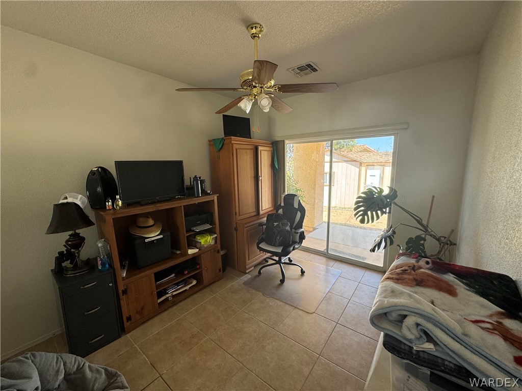 4029 Roma Road Kingman, AZ 86401 - Photo 32 of 90 The room features tiled flooring, a ceiling fan, and sliding glass doors that open to an outdoor patio area