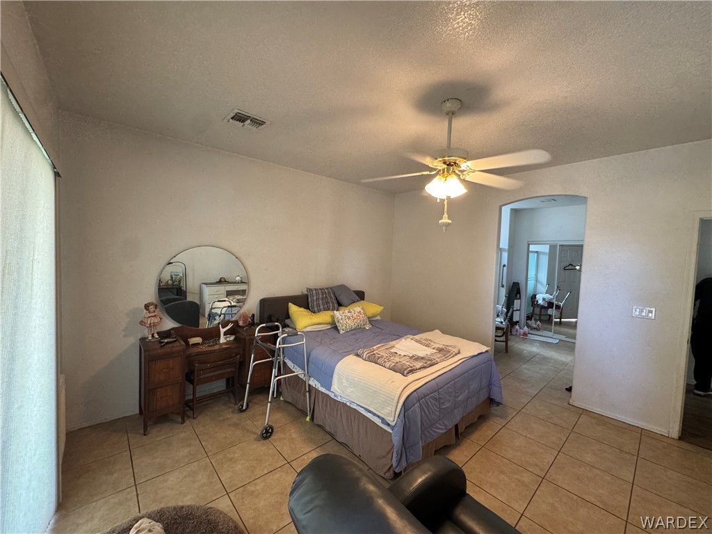 4029 Roma Road Kingman, AZ 86401 - Photo 39 of 90 This room features tiled flooring, a ceiling fan, and an arched doorway