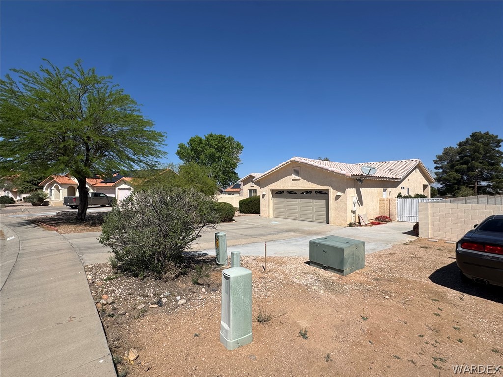 4029 Roma Road Kingman, AZ 86401 - Photo 4 of 90 The property features an attached garage with a paved driveway and a tiled roof