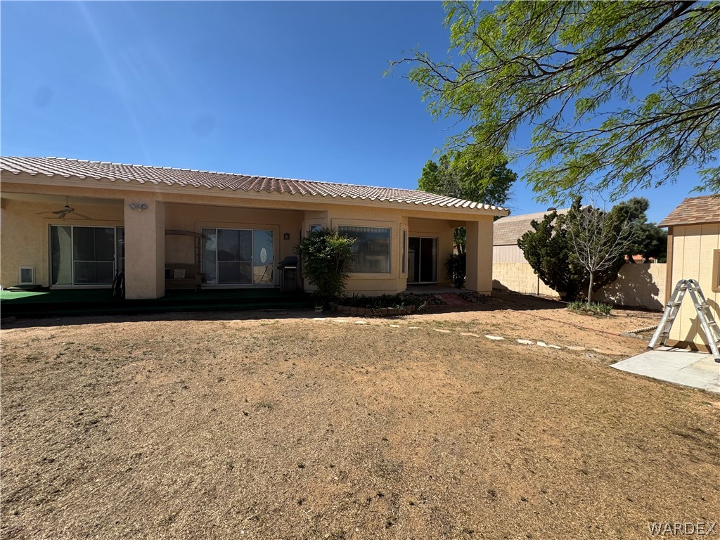 4029 Roma Road Kingman, AZ 86401 - Photo 53 of 90 The property features a spacious backyard with a patio, a detached shed, and mature trees