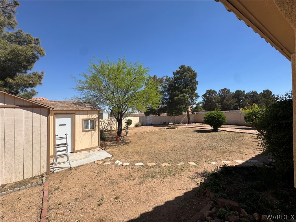 4029 Roma Road Kingman, AZ 86401 - Photo 55 of 90 The property features an extensive backyard with a storage shed, a tree, and a stone path