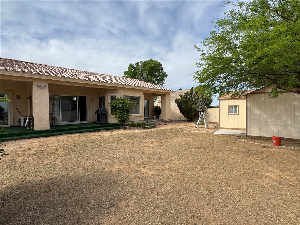 4029 Roma Road Kingman, AZ 86401 - Photo 65 of 90 The property features a stucco exterior, a covered patio area with green turf, and sliding glass doors