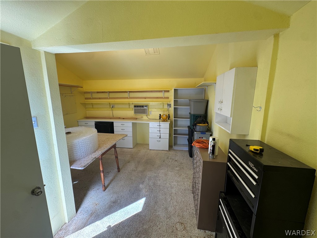 4029 Roma Road Kingman, AZ 86401 - Photo 75 of 90 This versatile space features extensive built-in shelving, white cabinetry, and a countertop workspace