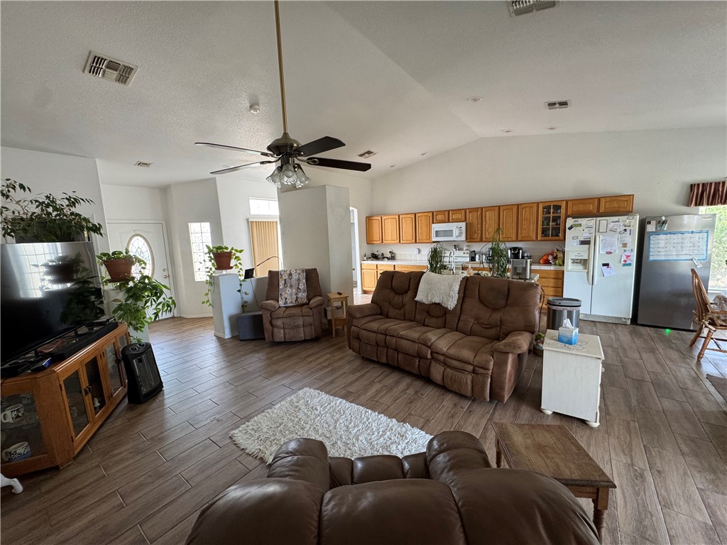 4029 Roma Road Kingman, AZ 86401 - Photo 8 of 90 Spacious living area featuring vaulted ceilings, a ceiling fan, and wood-look tile flooring