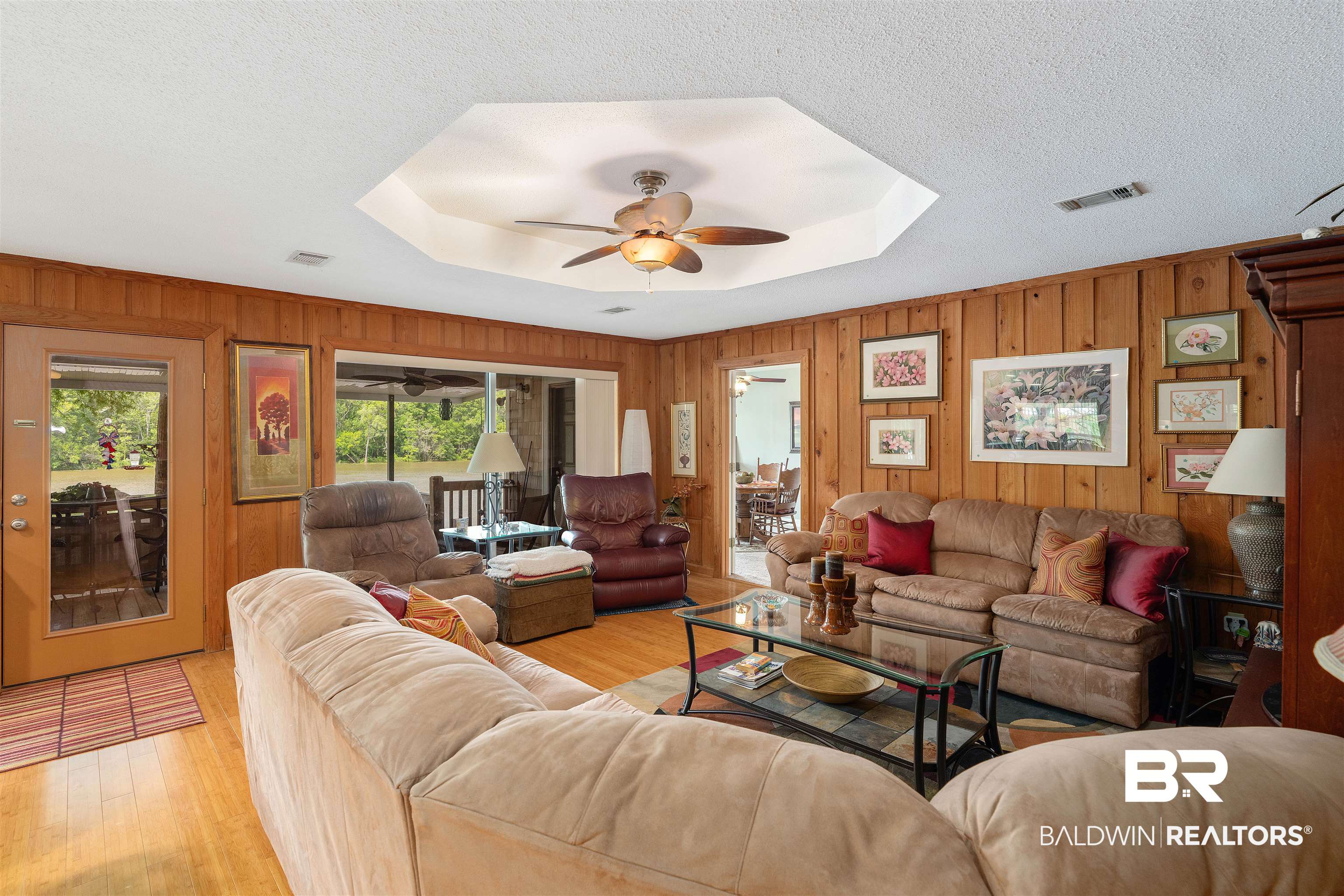 8157 Bryant's Lndg Road Stockton, AL 36579 - Photo 19 of 23 Living room with a textured ceiling, light hardwood / wood-style flooring, ceiling fan, and wood walls