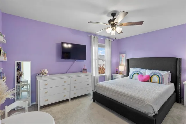 a bedroom with a bed a chandelier and a flat screen tv