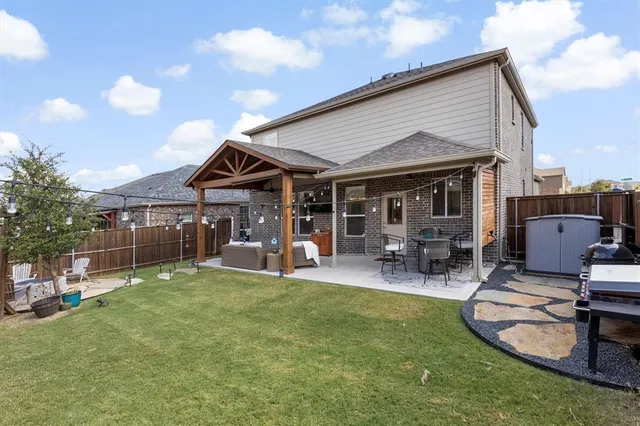 a view of a house with a patio and a yard
