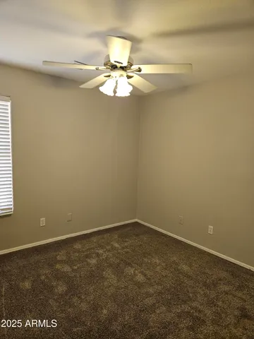 en empty room with windows and fan