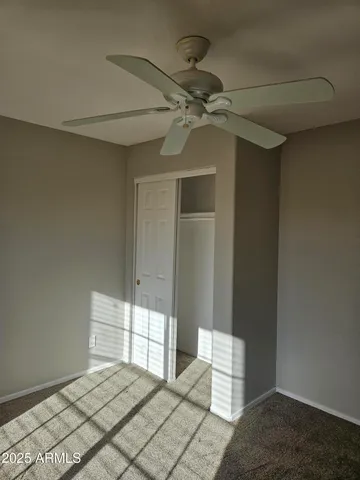 a bedroom with a bed and a chandelier fan