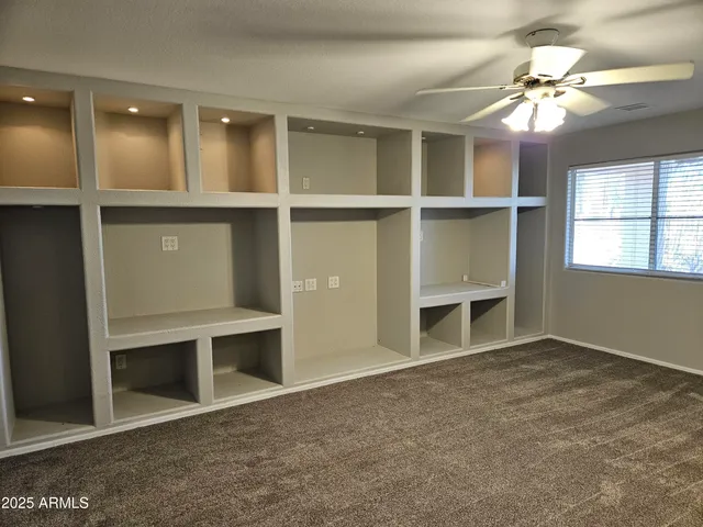 an empty room with windows and cabinet