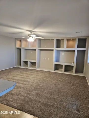 a view of an empty room with a fireplace and a window