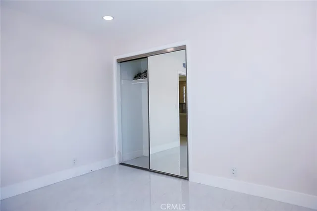 a view of a hallway with wooden floor and a bathroom