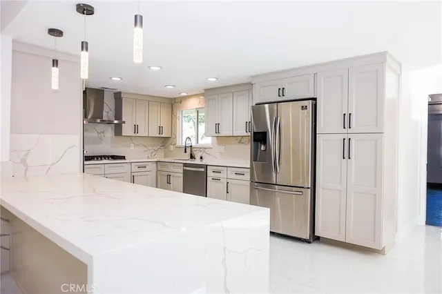 a kitchen with stainless steel appliances a refrigerator sink and microwave